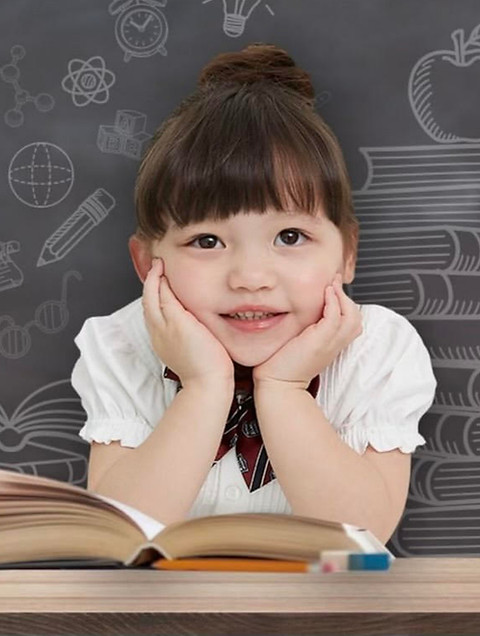 A young WizIsland learner smiling over an open book